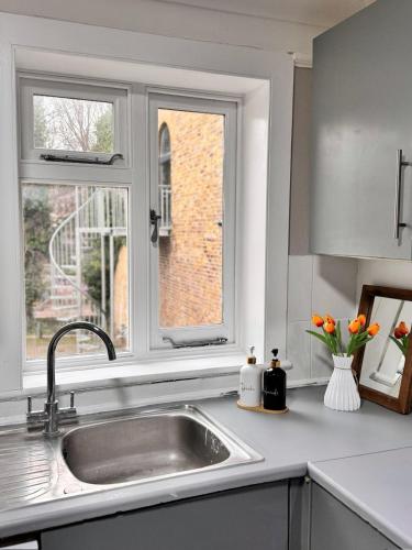 a kitchen counter with a sink and a window at Luxury and Stylish Ensuits in London