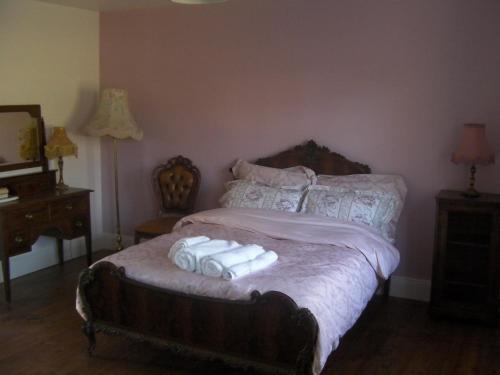 a bedroom with a bed with three towels on it at Tinnakilly Lodge, Spaciously luxurious home near Aughrim Wicklow in Aughrim