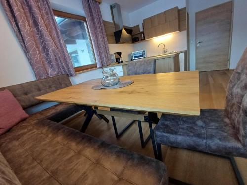 a wooden table in a kitchen with two chairs at Ferienwohnungen Guglhof Mariapfarr in Mariapfarr