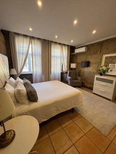 a bedroom with a large bed and a living room at Turra Residence in Porto