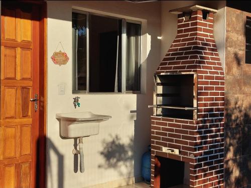 a kitchen with a brick oven and a sink at Recanto Bela Vista in Peruíbe