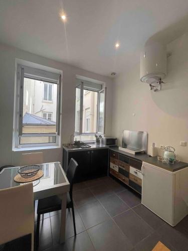 une cuisine avec une table et un comptoir dans l'établissement Le Masséna d'Or, Calme, Métro, et Parc Tête D'or, à Lyon