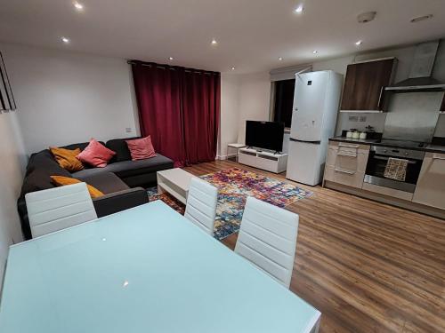a living room with a couch and a kitchen at London Apartment with Wembley view in London