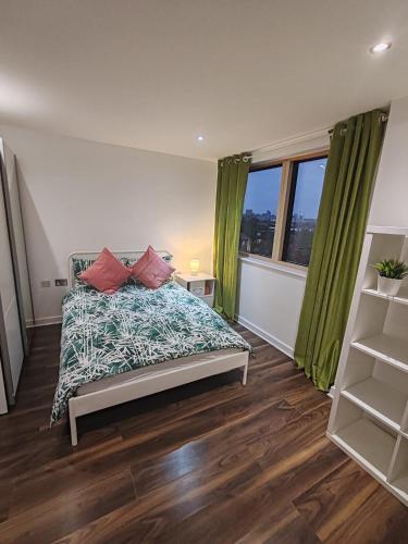 a bedroom with a bed and a large window at London Apartment with Wembley view in London