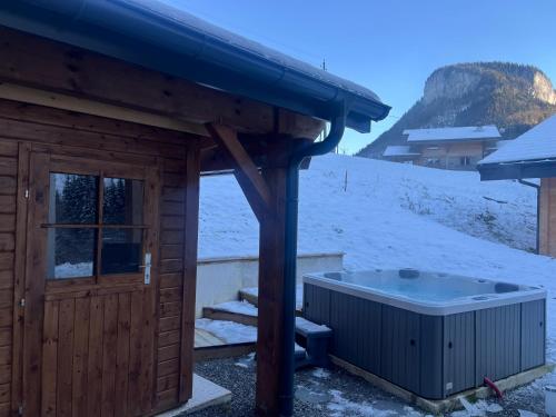 a sauna with a hot tub in the snow at Villa luxueuse avec sauna et jacuzzi in Bellevaux
