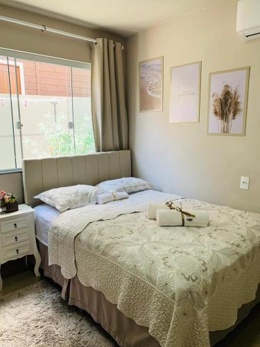 a bedroom with a large bed and a window at Flet dos sonhos in Florianópolis