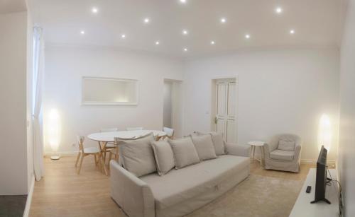 a living room with a white couch and a table at Casa do Colégio Downtown Private Suite 61 in Ponta Delgada