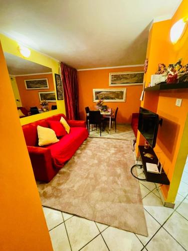 a living room with a red couch and a table at Casa di Cricci in Sestriere