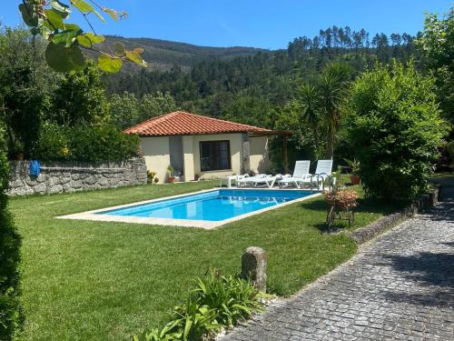ein Haus mit einem Swimmingpool im Hof in der Unterkunft Leiras da Cachada - Gerês in Valdosende
