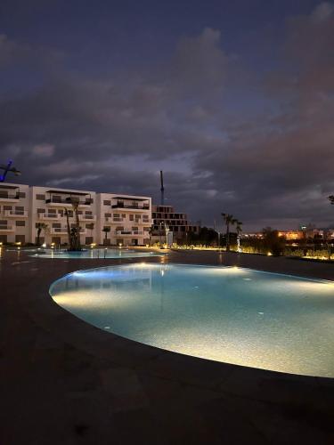 an empty swimming pool in front of a building at night at Luxury apartment with 3 pools in Cabo Negro