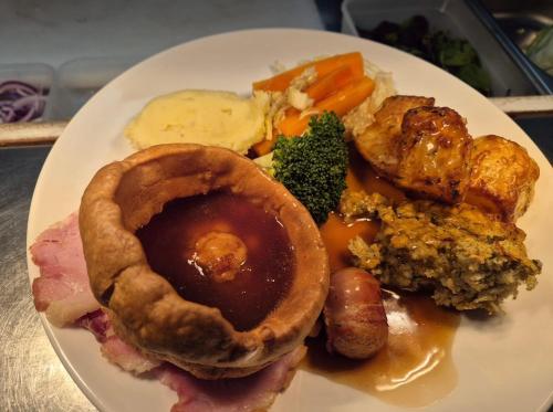 a white plate of food with meat and vegetables at The Ladybower Inn in Bamford