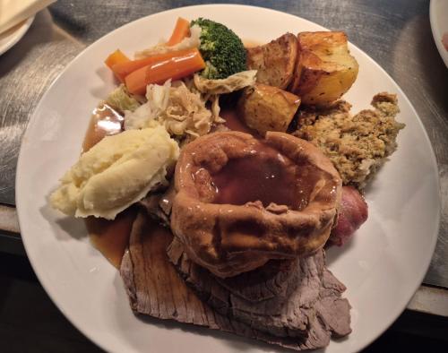 a plate of food with meat and vegetables on a table at The Ladybower Inn in Bamford