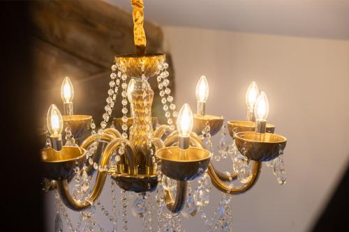 a gold chandelier with lights on a wall at Bradford Luxury Central Apartment in Bradford