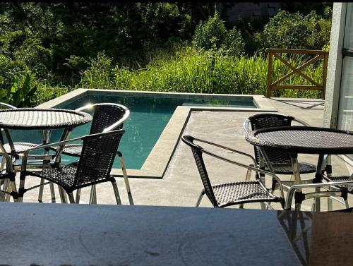 a group of chairs and tables next to a swimming pool at VILLAGE Vista do Cruzeiro ITAITU in Jacobina