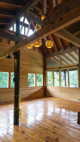 an empty room with wooden floors and chandeliers at Boscana Forest Resort & Residence in Coscomatepec de Bravo