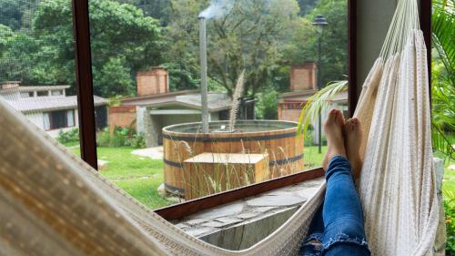 a person laying in a hammock looking out of a window at Boscana Forest Resort & Residence in Coscomatepec de Bravo