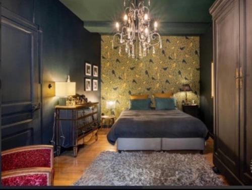 une chambre avec un lit et un lustre dans l'établissement Le Prestige Vieux Lyon, Duplex Vue sur la Saône, à Lyon