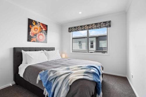 a bedroom with a bed and a window at Contemporary 3 Bed Townhouse Near CBD & Hospital in Hamilton