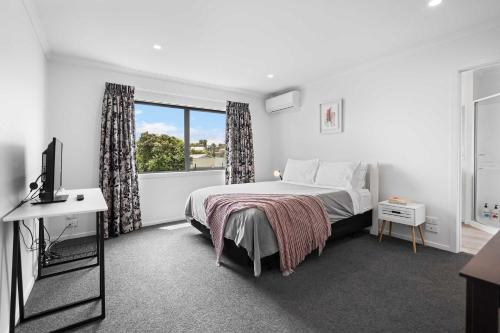 a white bedroom with a bed and a window at Contemporary 3 Bed Townhouse Near CBD & Hospital in Hamilton