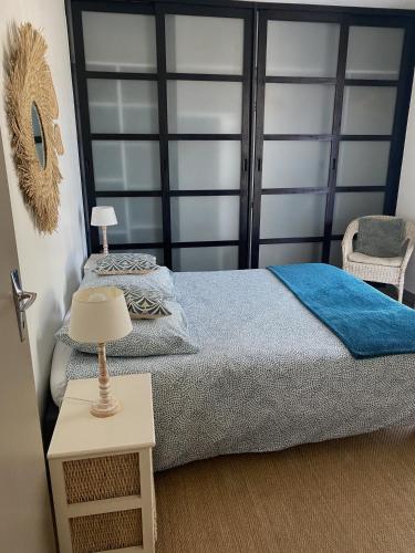 une chambre avec un lit avec une couverture bleue dans l'établissement Maison Sable à Rivedoux Plage 17940, à Rivedoux-Plage