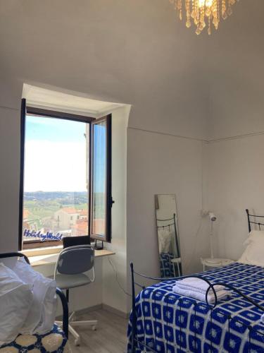 a bedroom with a bed and a window and a chair at Appartamentino nel castello in Miglianico