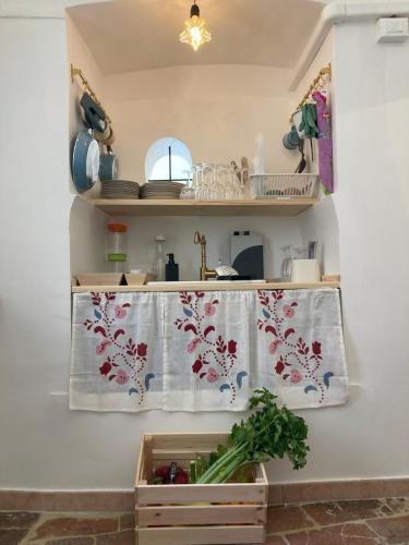 a kitchen with a table with a curtain on a wall at Appartamentino nel castello in Miglianico