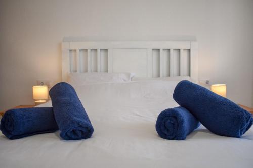a white bed with two blue towels on it at Ático centro Tarifa in Tarifa