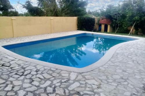 a swimming pool with blue water in a stone patio at Elegant Villa in Nagua with Private Pool and Jacuzzi in Nagua
