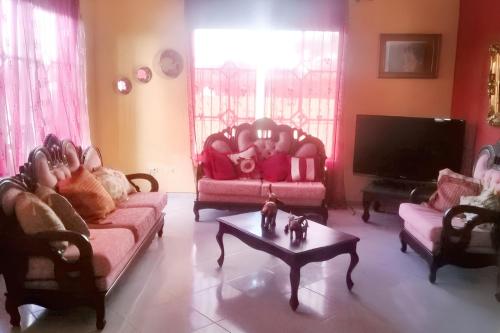 a living room with two couches and a tv at Elegant Villa in Nagua with Private Pool and Jacuzzi in Nagua