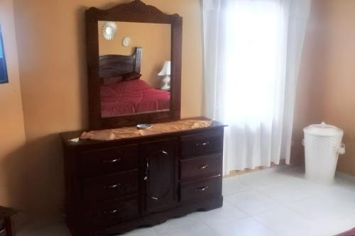a mirror on a dresser in a bedroom with a bed at Elegant Villa in Nagua with Private Pool and Jacuzzi in Nagua