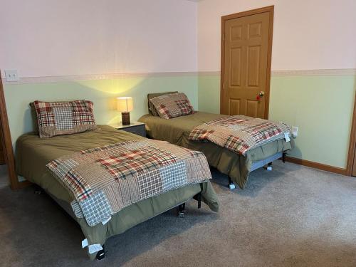 a room with two beds and a lamp on a table at Hidden Pines in Thendara