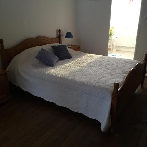 ein Schlafzimmer mit einem großen Bett mit zwei Kissen darauf in der Unterkunft Maison d'hôtes la Ferme De L'abbaye in Juilly
