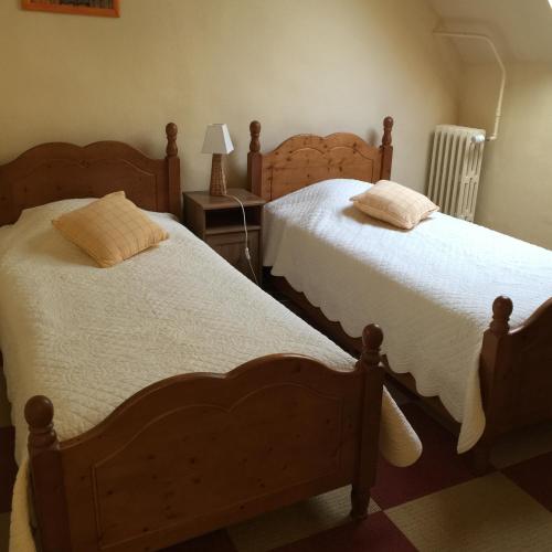 2 nebeneinander sitzende Betten in einem Schlafzimmer in der Unterkunft Maison d'hôtes la Ferme De L'abbaye in Juilly