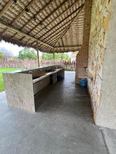 a pavilion with a bench and a brick wall at Chalé Encantador com Rooftop Privativo in Cajueiro