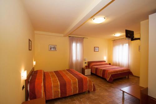 pokój hotelowy z 2 łóżkami i stołem w obiekcie Camere Santucci w Asyżu