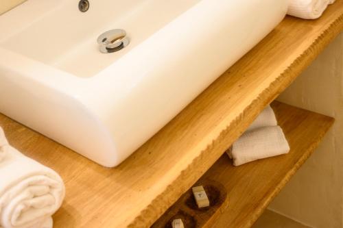 a bathroom with a white sink on a wooden shelf at Chez Marie & Philippe Ti'Kaz Vanille in Cadet
