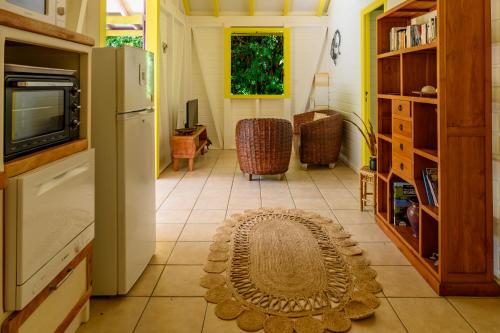 a room with a refrigerator and a rug on the floor at Chez Marie & Philippe Ti'Kaz Vanille in Cadet