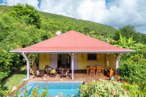 a yellow house with a deck and a swimming pool at Chez Marie & Philippe Ti'Kaz Vanille in Cadet
