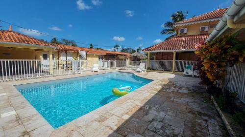- une piscine avec un flotteur au milieu d'une maison dans l'établissement Location saisonnière dans résidence avec piscine, à Les Trois-Îlets