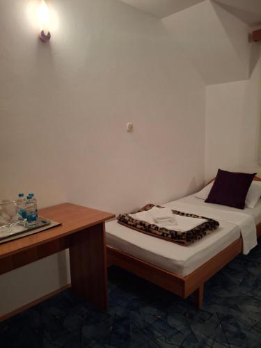 a small bedroom with a bed and a desk at Restoran Prenociste As in Trnovo