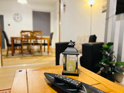 a lantern sitting on a table with a remote control at Cosy 3BDR In Levenshulme-Close To Manchester City Centre And Stockport Town- Free Parking- WiFi in Manchester