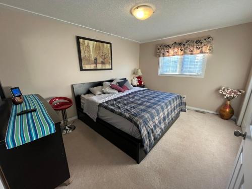 a bedroom with a bed and a table in it at Spacious and Charming Bungalow Retreat (Close to Many Amenities) in Kingston