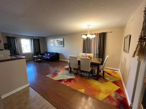 a dining room with a table and chairs on a rug at Spacious and Charming Bungalow Retreat (Close to Many Amenities) in Kingston