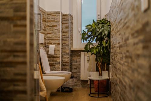 a bathroom with a toilet and a potted plant at CLavi Apartament in Sassari