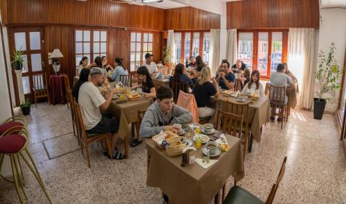 a group of people sitting at tables in a restaurant at Hotel Carmen in San Bernardo