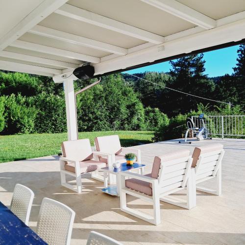 a white pergola with chairs and a table on a patio at TerrazzaPonente in Monte San Pietro