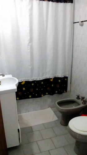 a bathroom with a toilet and a shower curtain at Mirador Azul Las Grutas in Las Grutas