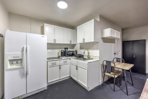 a kitchen with white cabinets and a table and a refrigerator at Elegant Private Studio Sleeps 4! 10Min to Strip! in Las Vegas