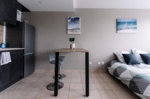 une chambre avec un lit et une table dans une pièce dans l'établissement Le Nid Dardilly, Studio confort, calme, parking, Idéal pro, à Dardilly