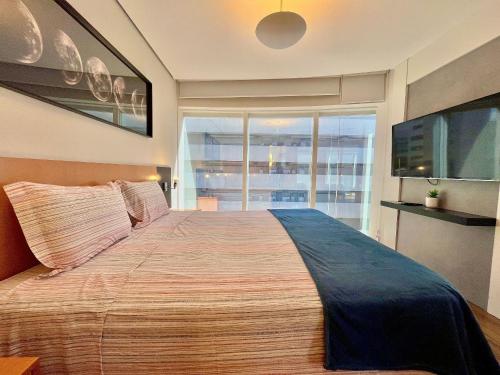 a bedroom with a large bed with a large window at LFlats no Hotel Stella Vega (EX-Mercury Ibirapuera) in Sao Paulo